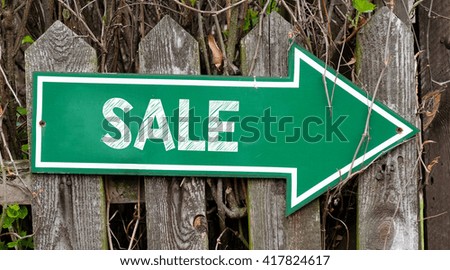 Green signboard with sale inscription. Green signboard with sale inscription on wooden fence.