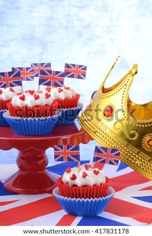 Holiday party cupcakes with UK flags on red cake stand on large flag. 