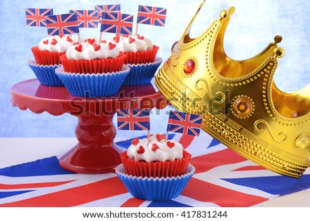 Holiday party cupcakes with UK flags on red cake stand on large flag. 