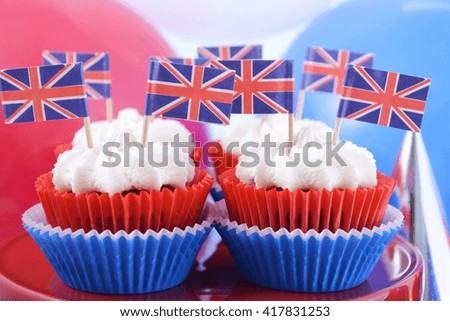 Holiday party cupcakes with UK flags and red, white and blue party hats and balloons.  