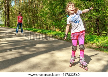 young girl in protective equipment and rollers in park, outdoor portrait
