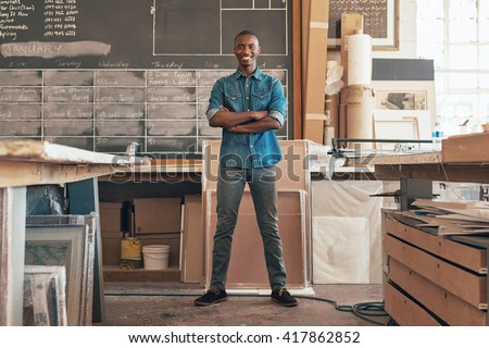 Proud African small business owner standing in his studio workshop