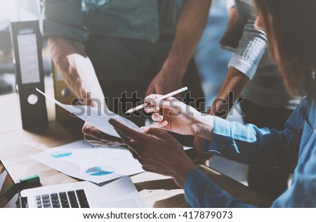 Photo team work process,holding contract hand,signs documents. Account managers young crew works with startup project.New idea presentation, analyze marketing reports. Blurred, film effect, horizontal Royalty-Free Stock Photo #417879073