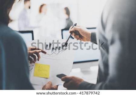 Business meeting image.Photo statistics document holding woman hand.Managers crew working with new startup project.Idea presentation,analyze marketing plans. Blurred background,film effect. Horizontal