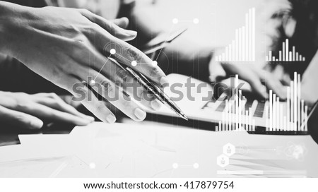 Business concept photo.Meeting of investment managers.Woman holding pen hand, man using laptop background.Graphics icon,worldwide stock exchanges interfaces. Horizontal. Film effects. Black and White