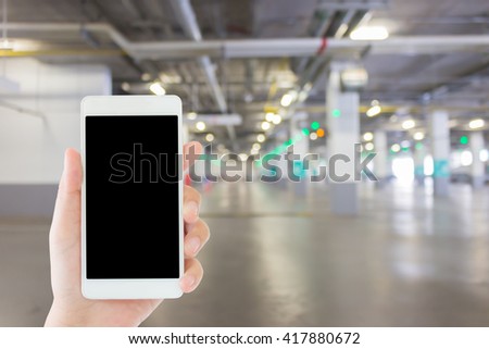 woman use mobile phone and blurred image of car park