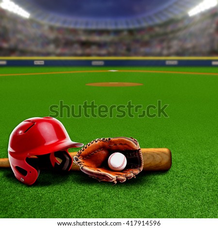 Baseball stadium full of fans in the stands with helmet, bat, glove and ball on the field. Deliberate focus on equipment and foreground with shallow depth of field on background. Copy space.