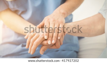 Composite image of nurse holding patient hand on a bed