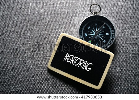 Mentoring word - business tips handwriting on label with compass