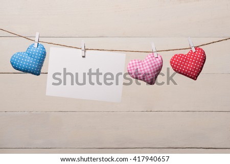 Blank instant photo and small red paper heart hanging on the clothesline. On white wooden background. Love heart hanging on wooden texture background, valentines day card concept