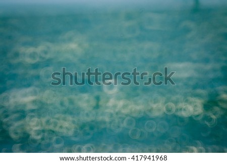 blurred sunlight reflected in the blue sea waves at daytime