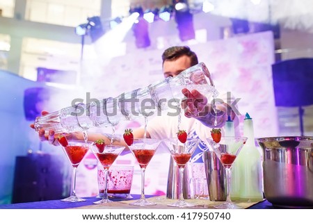 Barman show. Bartender pours alcoholic cocktails. Royalty-Free Stock Photo #417950740