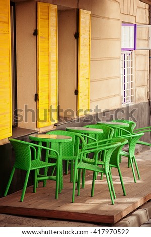 color cafe in old european city with yellow windows and green chairs