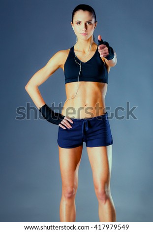 Portrait of a happy fitness woman showing ok sign