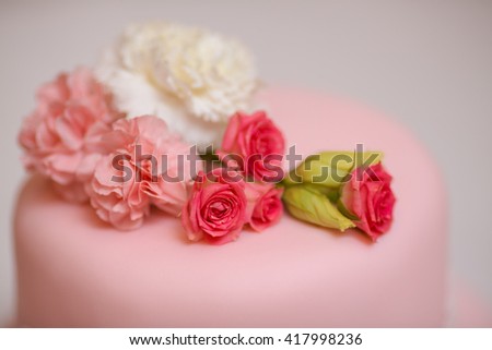 Close-up pink wedding cake with roses against  copy space background