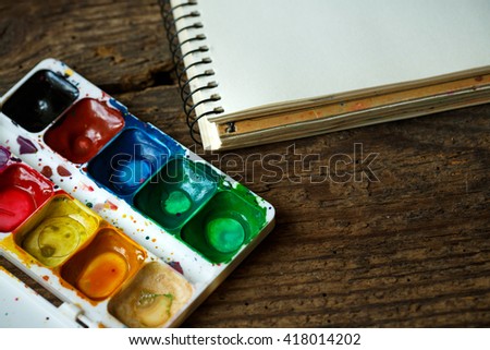 Art of Painting. Painting set: paper, brushes, paints, crayons, watercolor, acrylic paint on a wooden background