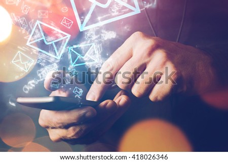 Man sending e-mail message to mailing list contacts using smartphone, close up of hands holding phone. Royalty-Free Stock Photo #418026346