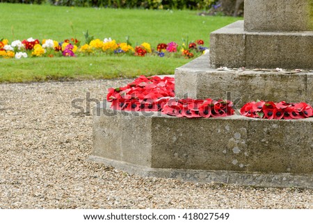 Poppy wreaths at base of war memorial statue