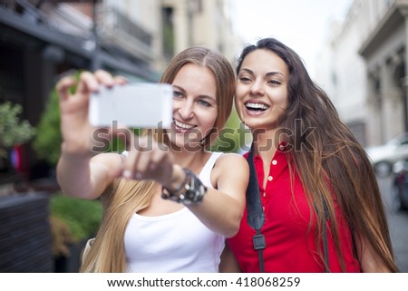 Close up lifestyle portrait of girls best friends makes funny grimaces on camera laughing together.Two women posing outdoor