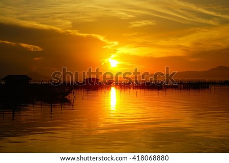 Amazing sunset with silhouette image stone,mountain and Lake view as a foreground. Soft focus due to long exposure shot. Nature composition:Ideal use for background.
