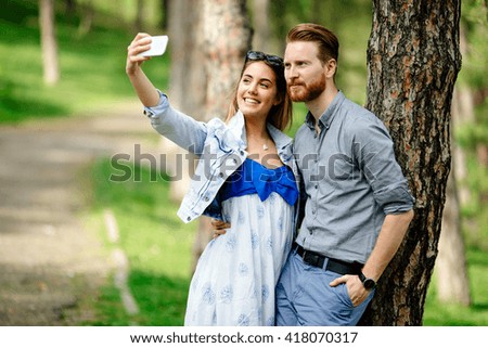 Beautiful couple in love taking selfies outdoors in park