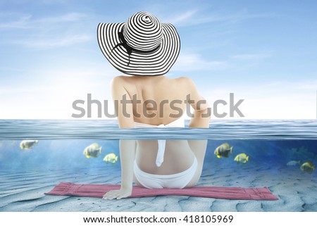blurred background of underwater and white bikini and woman in hat 