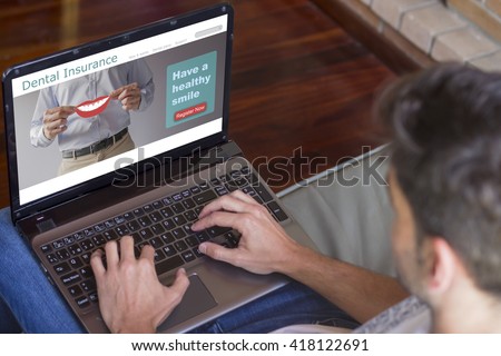 Close-up top view of young man at home working on laptop with dental insurance website on screen. All screen graphics are made up.