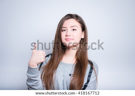 beautiful girl shows a thumbs-up sign close-up isolated on white background