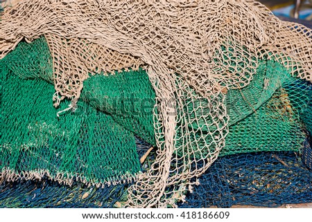 Close up of green, white, brown and blue fishing net. Background