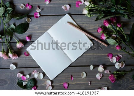 Stylish mock up to display your artworks. Flowers mock up on rustic background. Have a blank notebook and roses.