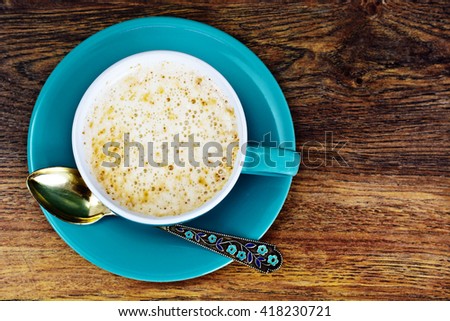 Coffee with milk, cappuccino in a blue retro cup. Studio Photo