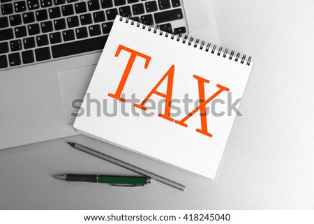 Tax Concept. Notebook on laptop keyboard, on light background