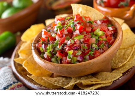 A delicious home made salsa pico de gallo with tomato, red onion, lime, cilantro, and jalapeno pepper. Royalty-Free Stock Photo #418247236