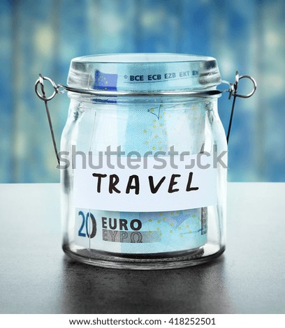 Jar for savings full of banknotes on wooden background