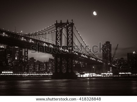 Moon over Manhattan. Silhouette of Manhattan Bridge and Manhattan Skyline at nigh. Old photo stylization, film grain added. Sepia toned