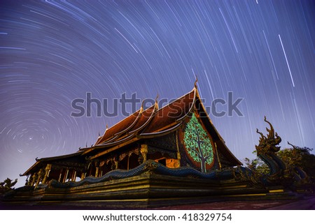 Temple Sirindhorn Wararam Phuproud in Ubon Ratchathani Province at night and  Star rotation.This long exposure astronomical
