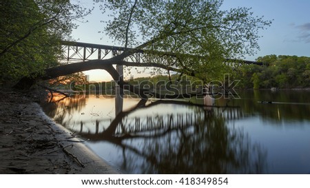 The Short Line Bridge and Trees Reflect in the Mississippi River at Dusk in this Generic Looking Minnesota Landscape