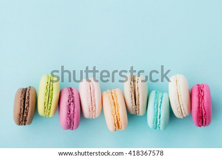 Cake macaron or macaroon on turquoise background from above, colorful almond cookies, pastel colors, vintage card, top view Royalty-Free Stock Photo #418367578