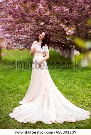 portrait retro vintage happy woman . beautiful spring walk in tree woods cherry blossom in April lady in a long dress pastel. Old style gown outfit royal cute pretty princess. sakura blooming garden