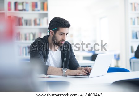 student preparing exam and learning lessons in school library, making research on laptop and browse internet Royalty-Free Stock Photo #418409443
