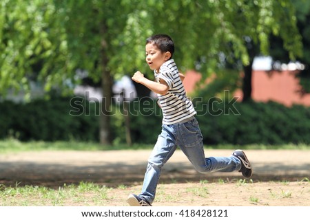 Japanese boy running on the grassÃ£??(first grade at elementary school) Royalty-Free Stock Photo #418428121