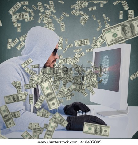 Serious burglar hacking into laptop against blue background