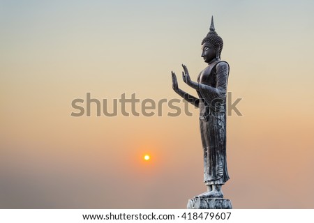 The Statue of Buddha on sunset sky background.