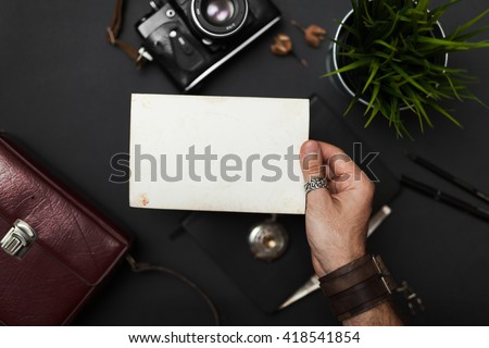 Photo in the hand, vintage style, on the black table, frame