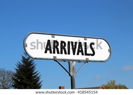 arrivals - white metal sign on blue sky background