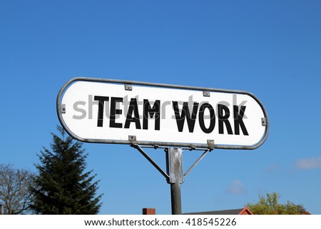 team work - white metal sign on blue sky background