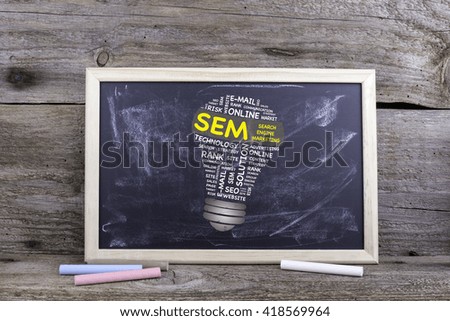 SEM (Search Engine Marketing) bulb word cloud. Chalk board on a wooden table