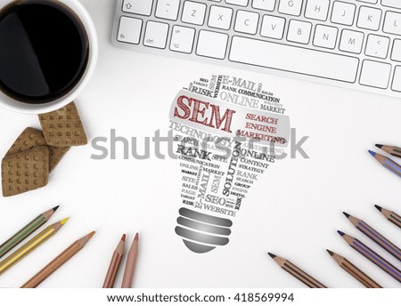 SEM (Search Engine Marketing) bulb word cloud. White office desk