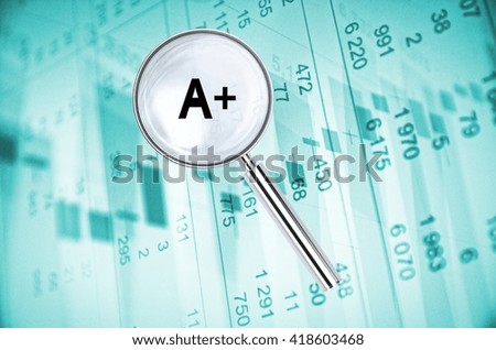 Magnifying lens over background with building icon and text A+, with the financial data visible in the background. 3D rendering.