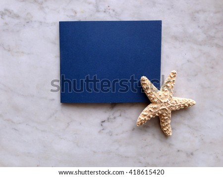 Blue black card on grey marble background with sea star